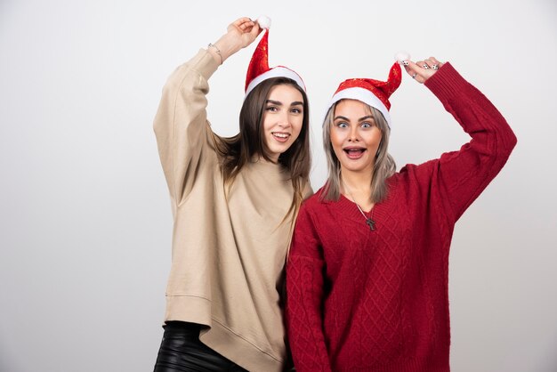 Imagen de una mujer feliz sosteniendo un gorro de Papá Noel.