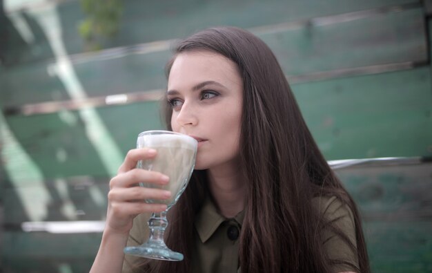 Imagen de una mujer hermosa con fascinantes ojos verdes tomando un café