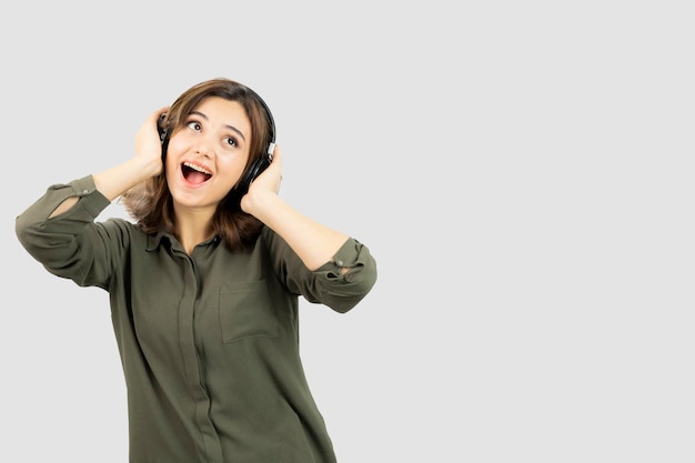 Imagen de mujer joven y atractiva en auriculares escuchando una canción. foto de alta calidad