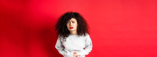 Foto gratuita imagen de una mujer joven con dolor de estómago que se dobla por el dolor y se queja de un doloroso acúmulo menstrual