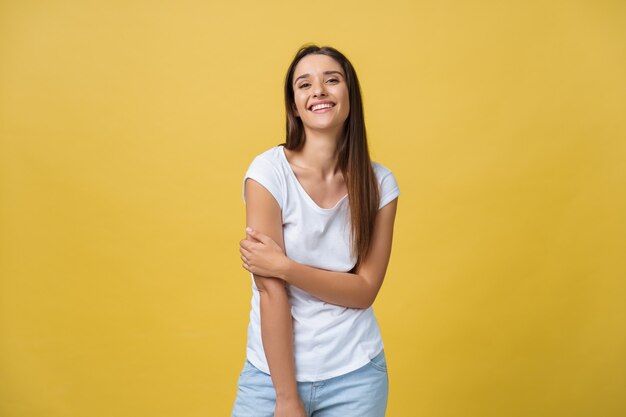 Imagen de mujer joven emocionada que se encuentran aisladas sobre fondo amarillo. Mirando la cámara.