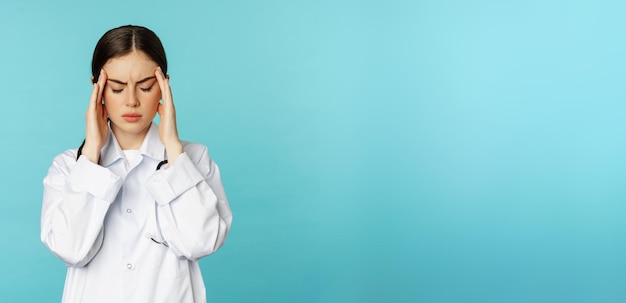 Foto gratuita imagen de una mujer médico personal médico haciendo muecas de incomodidad con dolor de cabeza migraña sensación de