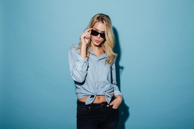 Imagen de una mujer rubia genial en camisa y gafas de sol