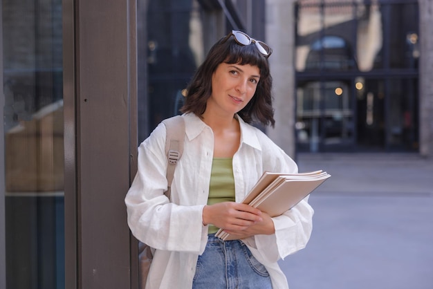 Imagen de mujer sosteniendo cuaderno y sonrisa