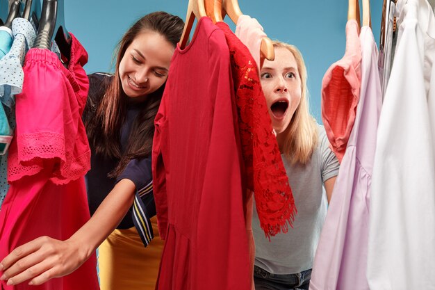 Imagen de mujeres bonitas que buscan un vestido mientras lo eligen.