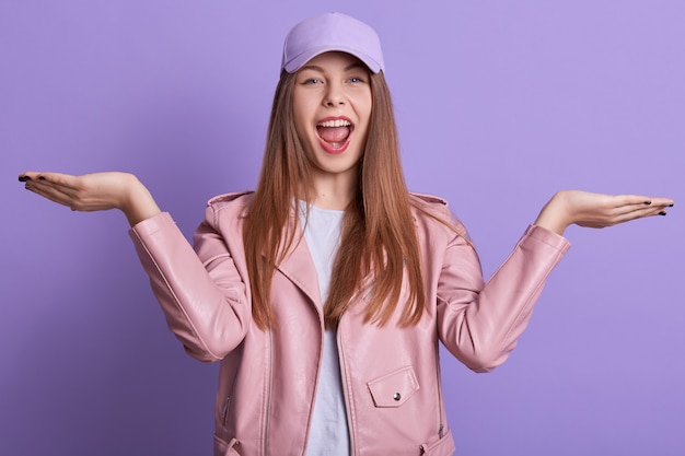 Imagen de niña estudiante feliz posando con las manos extendidas y gritando algo