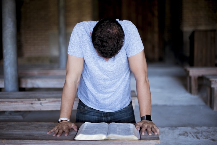 Foto gratuito imagen de primer plano de un hombre leyendo la biblia en una mesa de madera