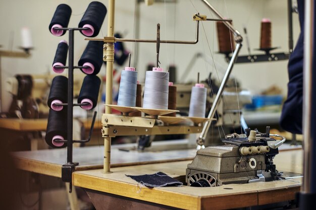 Imagen de primer plano de muchas bobinas con hilos en el taller de costura.