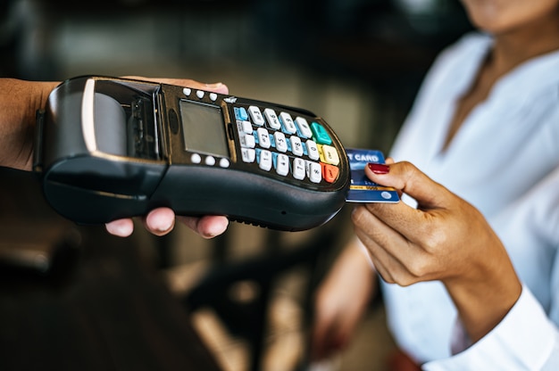 Foto gratuita imagen de primer plano de mujer pagando con tarjeta de crédito en café