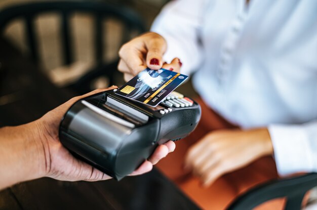 Imagen de primer plano de mujer pagando con tarjeta de crédito en café