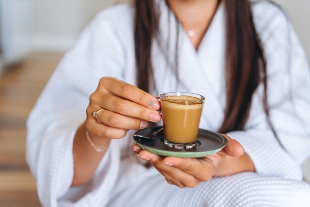 Imagen de primer plano de una mujer sosteniendo una taza de café.