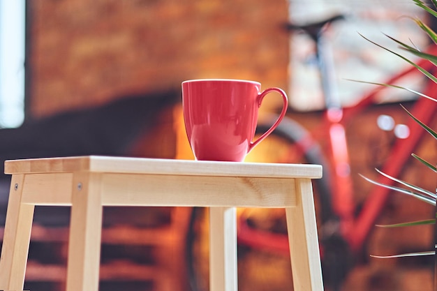 Imagen de primer plano de una taza de café roja sobre una mesa.