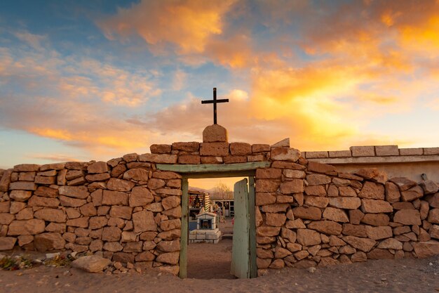 Imagen de una puerta antigua con una cruz bajo el gran cielo