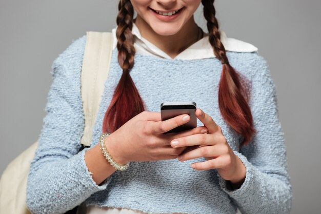 Imagen recortada de una colegiala sonriente con mochila