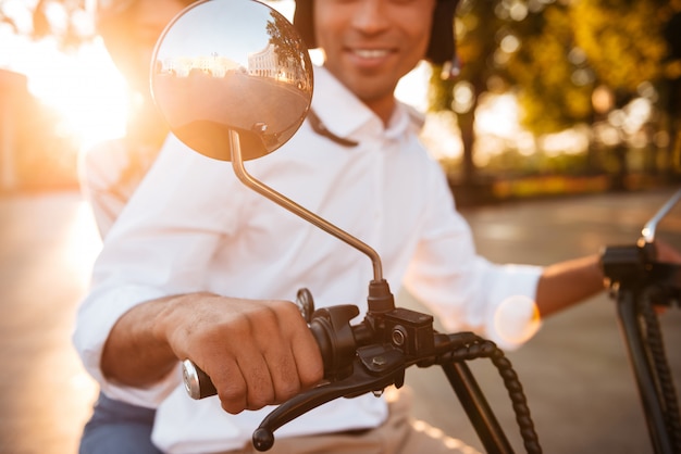 Foto gratuita imagen recortada de la feliz pareja africana monta en moto moderna en el parque