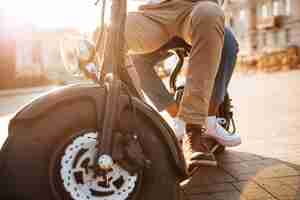 Foto gratuita imagen recortada de una joven pareja africana monta en moto moderna en la calle