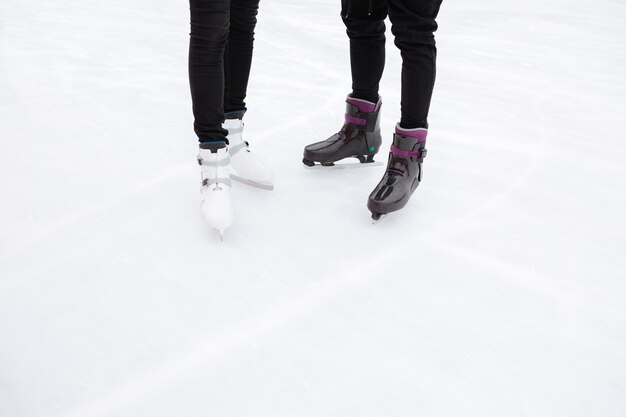 Imagen recortada de la joven pareja amorosa patinando en la pista de hielo