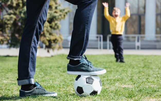 Imagen recortada de un padre jugando al fútbol con su hijo