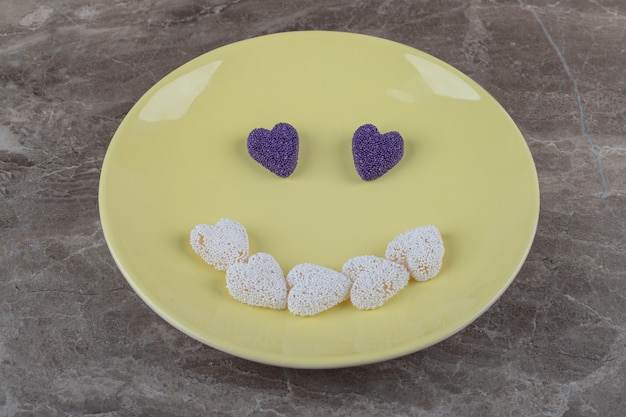 Foto gratuita imagen de sonrisa hecha de galletas en el plato sobre la superficie de mármol