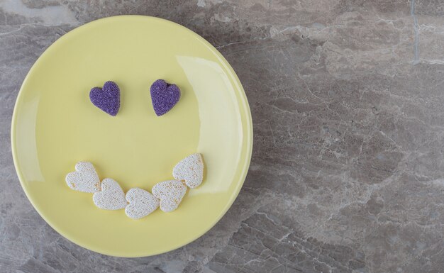 Imagen de sonrisa hecha de galletas en el plato sobre la superficie de mármol