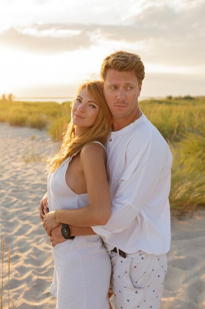 Imagen de verano al aire libre de la joven pareja elegante hermosa en la playa.