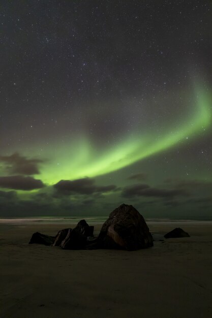 Imagen vertical del impresionante fenómeno de la aurora boreal en el Atlántico contra un cielo estrellado