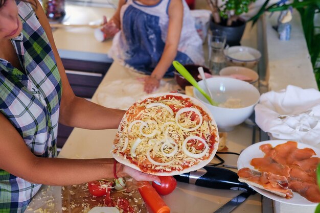 La imagen de la vista superior de una pareja hace pizza en una cocina.