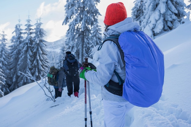 Imágenes de la espalda de un joven excursionista con un traje de esquí blanco y un sombrero de colores brillantes