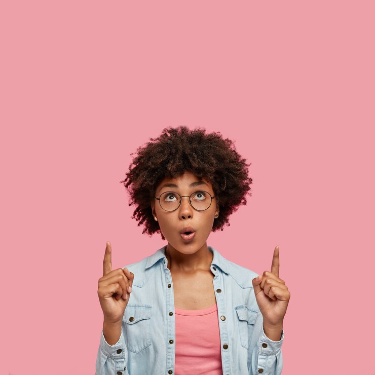 Foto gratuito impresionada hermosa mujer posando contra la pared rosa