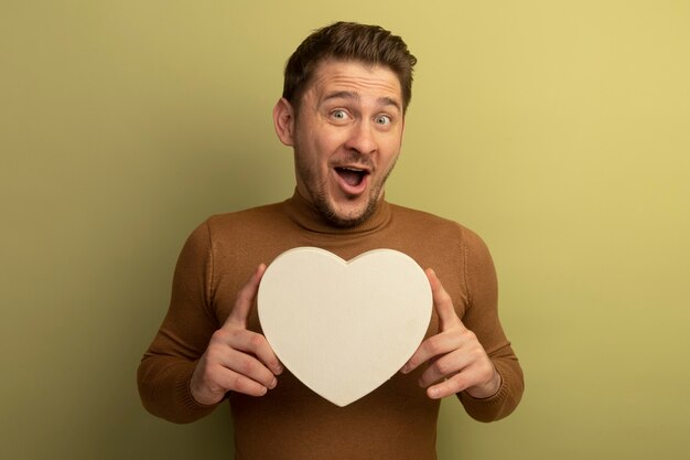 Impresionado joven guapo rubio con forma de corazón