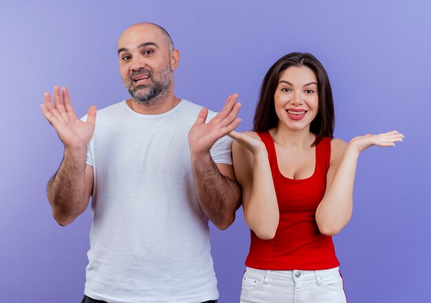 Impresionado pareja adulta mirando mostrando las manos vacías