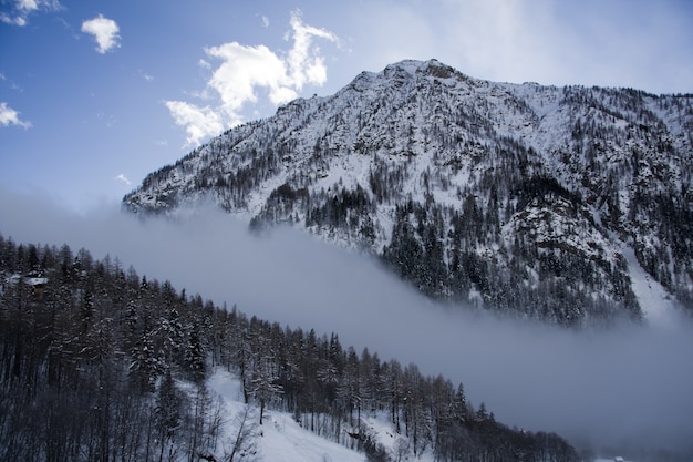 Impresionante paisaje de las montañas cubiertas de nieve bajo un pintoresco cielo nublado