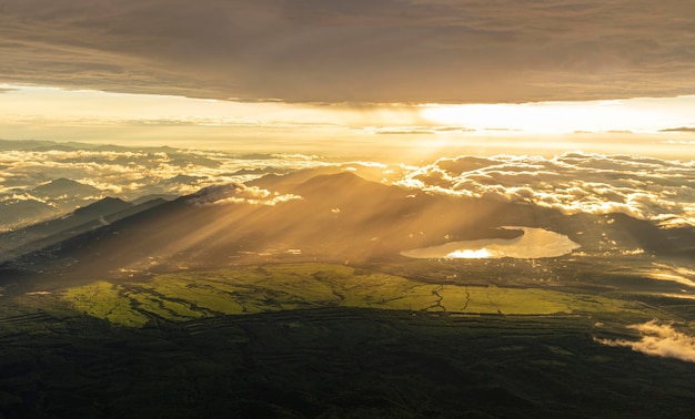 Foto gratuita impresionante paisaje montañoso con una puesta de sol vívida y colorida en el cielo nublado.