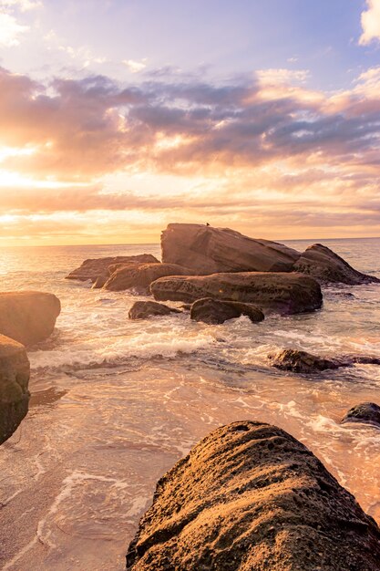 Impresionante paisaje de una playa rocosa en una hermosa puesta de sol