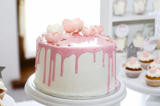 Impresionante pastel de cumpleaños cubierto con glaseado rosa y rosas