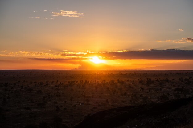 Impresionante puesta de sol en el cielo colorido sobre un desierto en Tsavo oeste, Kenia, Kilimanjaro