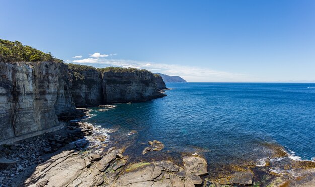 Impresionante tiro de alto ángulo de los acantilados cerca del agua pura de Eaglehawk Neck en Australia