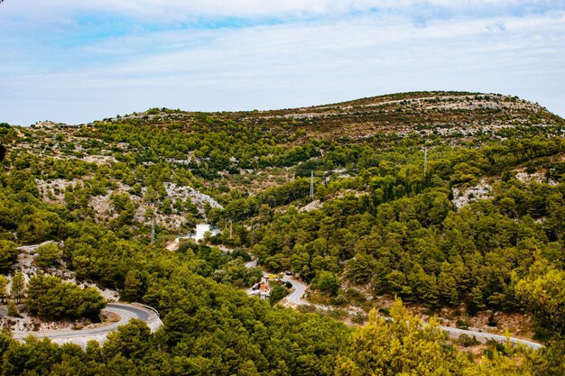 Impresionante tiro de alto ángulo de un paisaje verde montañoso bajo el cielo nublado