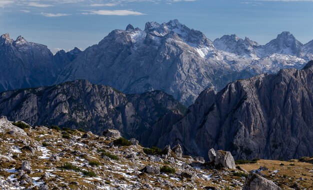 Impresionante tiro de rocas nevadas en los Alpes italianos bajo el cielo brillante