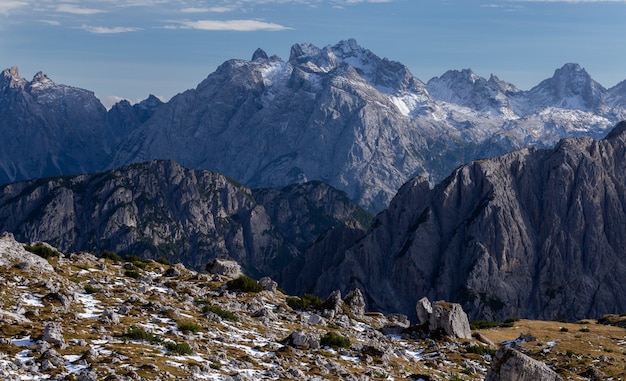 Impresionante tiro de rocas nevadas en los Alpes italianos bajo el cielo brillante