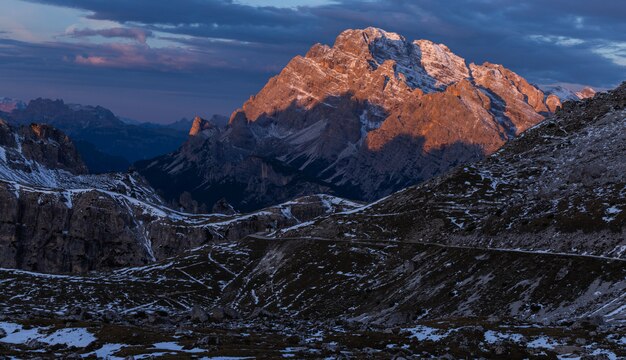 Impresionante toma de un paisaje en los Alpes italianos bajo el cielo nublado del atardecer