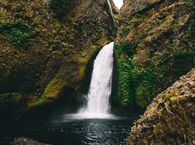 Impresionante toma de una pequeña cascada en las montañas