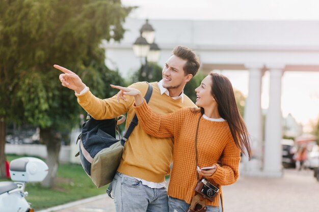 Impresionante turista sosteniendo smartphone y hablando con el hombre