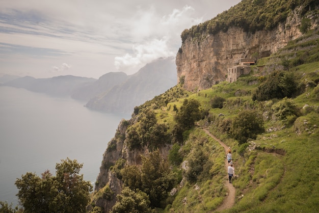 Foto gratuita impresionante vista de los acantilados cubiertos de hierba sobre el mar capturado en la costa de amalfi, italia