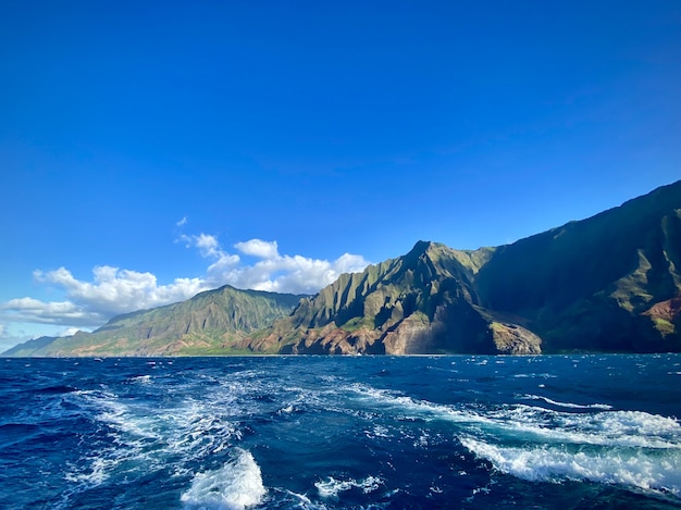 Foto gratuita impresionante vista de los acantilados de montaña sobre el océano bajo el hermoso cielo azul