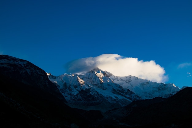 Impresionante vista de la cumbre de la montaña nevada en un cielo azul