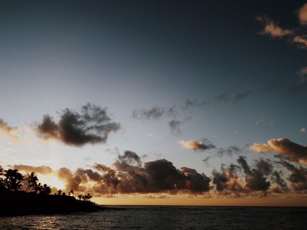 Impresionante vista de las hermosas nubes en el cielo sobre el océano tranquilo junto a la playa