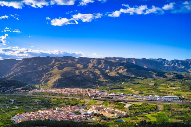 Impresionante vista del paisaje de una ciudad rodeada de colinas cubiertas de exuberante vegetación