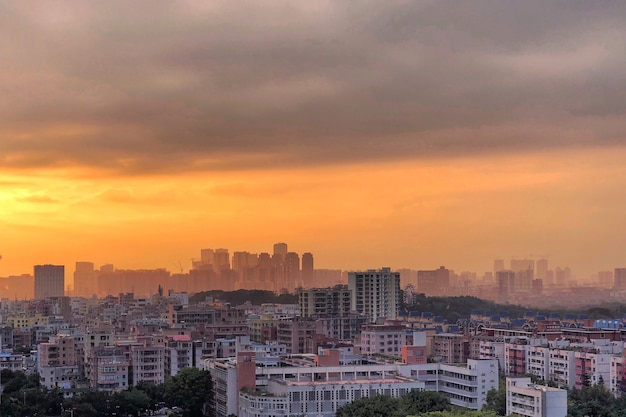 Impresionante vista de un paisaje urbano con nublado cielo anaranjado al atardecer