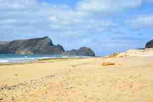 Foto gratuita impresionante vista de la playa de porto santo con una enorme formación rocosa